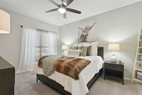 Bedroom with highland cow art and brown throw blanket at The Canyons Apartments, Texas, 76116