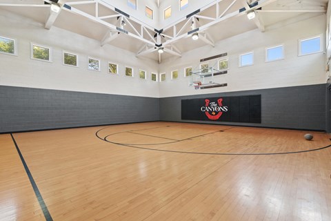 Full size indoor basketball court with branded wall at The Canyons Apartments, Texas