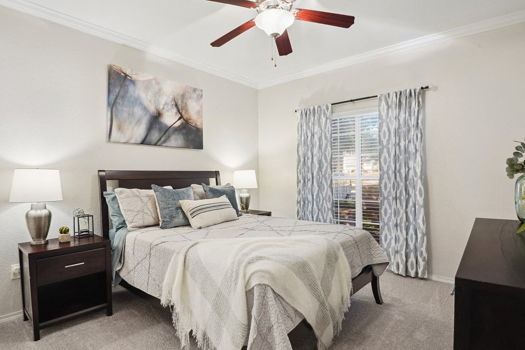 a bedroom with a large bed and a ceiling fan at La Ventura Apartments, Texas, 75093