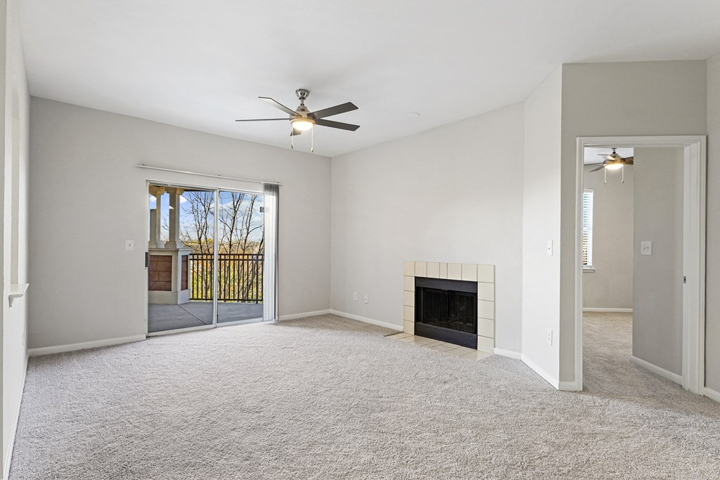 an empty living room with a fireplace and a ceiling fan at The Legends at Eagle Mountain Lake, Fort Worth