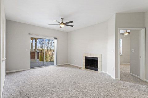 an empty living room with a fireplace and a ceiling fan at The Legends at Eagle Mountain Lake, Fort Worth