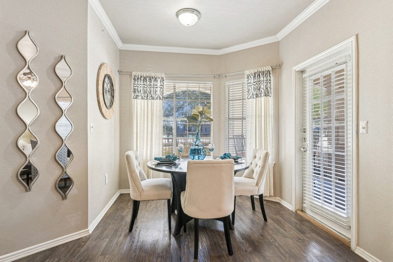 a dining room with a table and chairs and a window at TalaVera Apartments, San Antonio, Texas