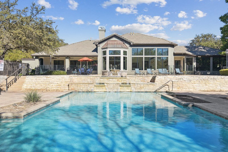 a pool with a house in the background at Legends on the Green Apartments, Texas