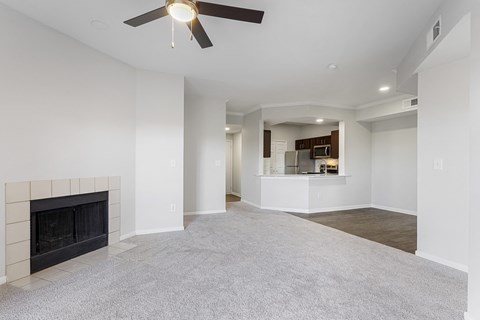 an empty living room with a fireplace and a ceiling fan at The Legends at Eagle Mountain Lake, Texas