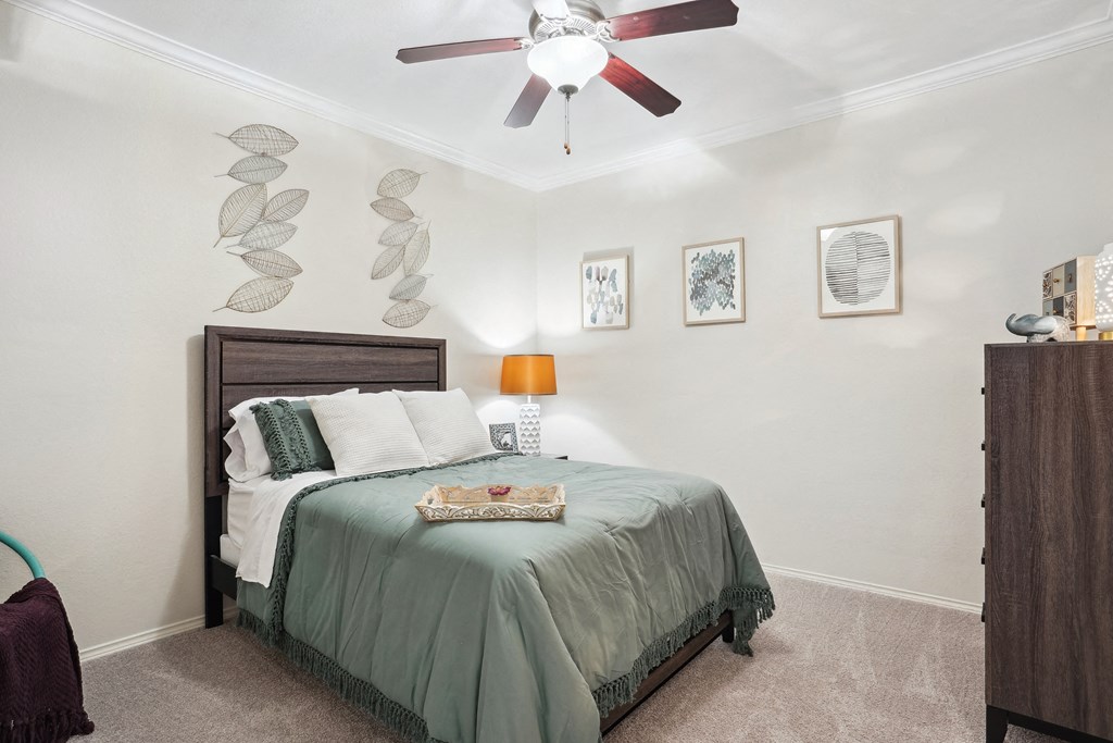 a bedroom with a bed and a ceiling fan at La Ventura Apartments, Texas, 75093