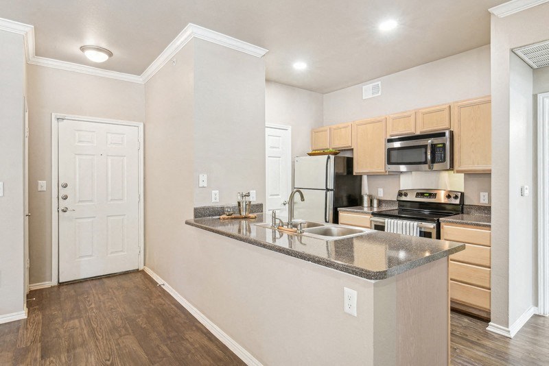 an empty kitchen with a counter top and a sink at TalaVera Apartments, San Antonio, TX