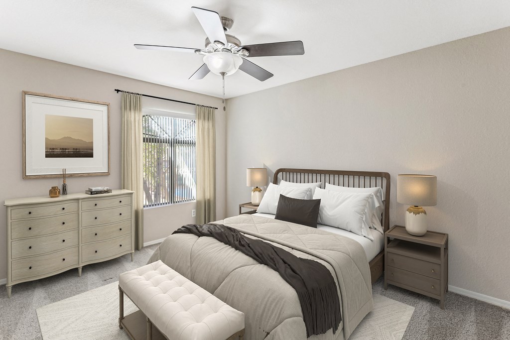 A bedroom with a large bed, a dresser, and a ceiling fan. at San Montego Apartments, Mesa, AZ