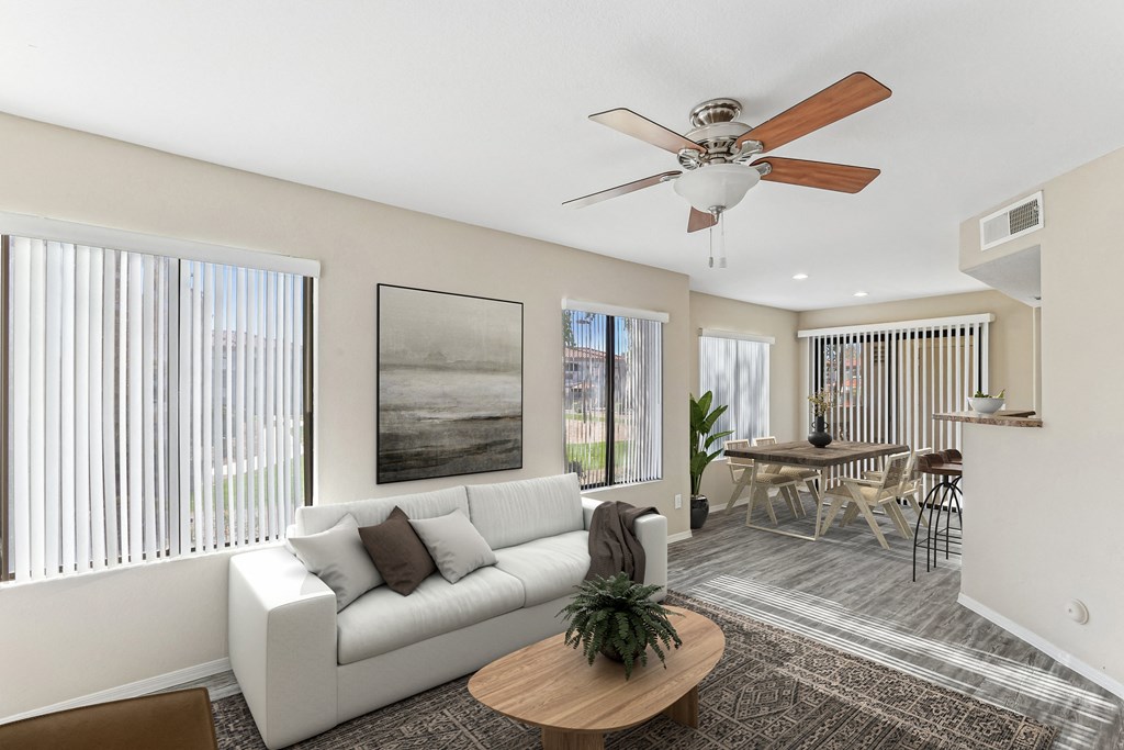 A living room with a white couch, a brown coffee table, and a ceiling fan. at San Montego Apartments, Arizona, 85206