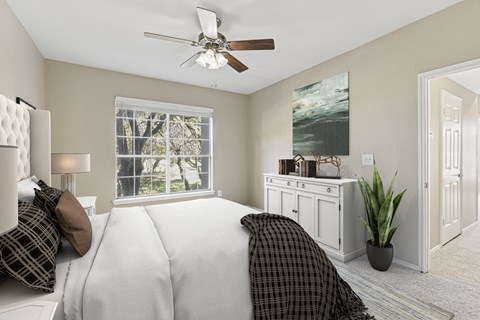 Bedroom with ceiling fan and white dresser at Legends on the Green Apartments, San Antonio, Texas