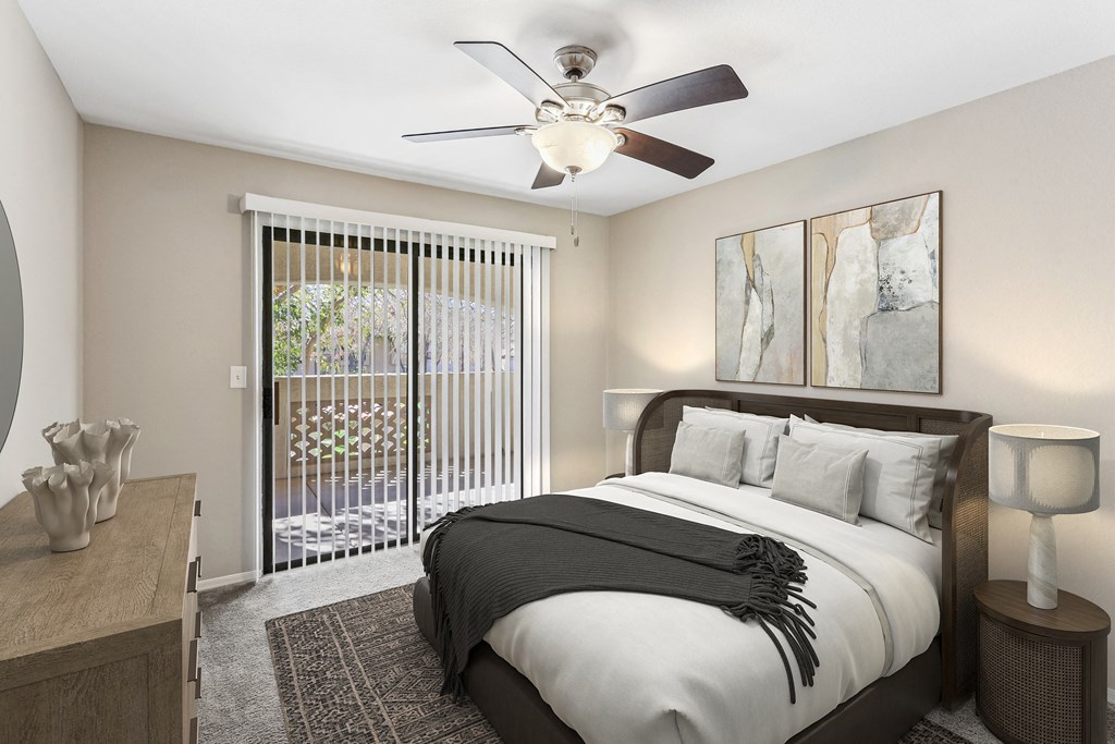 A bedroom with a large bed and a ceiling fan. at San Montego Apartments, Mesa, AZ, 85206