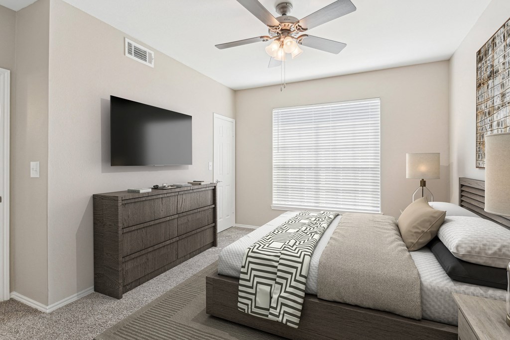 a bedroom with a large bed and a ceiling fan at TalaVera Apartments, Texas, 78232