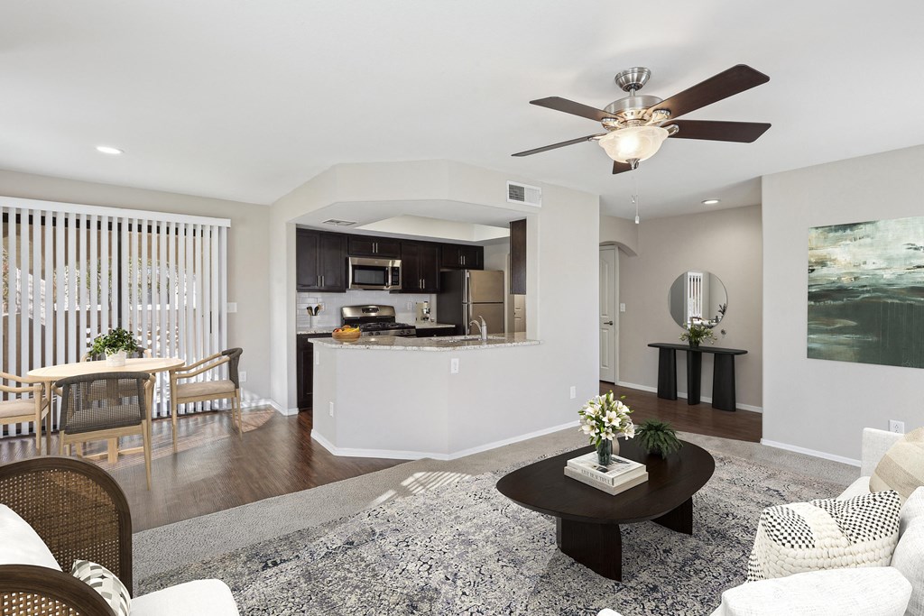 A modern living room with a dining area and kitchen in the background. at San Montego Apartments, Arizona