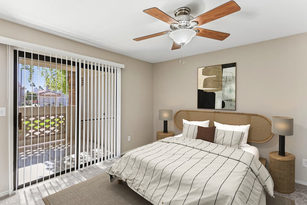 A bedroom with a bed, two lamps, and a ceiling fan. at San Montego Apartments, Mesa, AZ