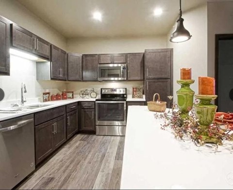 A kitchen with dark wood cabinets and stainless steel appliances.
