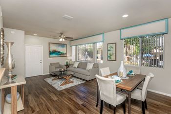 a living room and dining room with a couch and a table at The Covington by Picerne, Las Vegas, NV