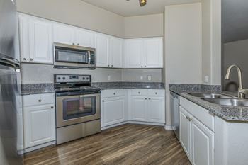 an empty kitchen with white cabinets and stainless steel appliances at The Aliante by Picerne, Scottsdale, 85259
