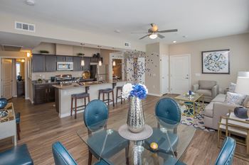 a living room and kitchen with a dining room table and chairs at The Passage by Picerne, Henderson, NV