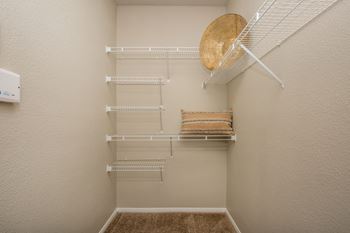 A small pantry with a white fridge and shelves at The Fairways by Picerne Apartments, Nevada, 89141
