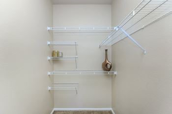 an empty closet with shelves and a guitar on the wall at The Covington by Picerne, Nevada, 89139