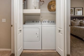 a washer and dryer in a small laundry room at The Fairways by Picerne Apartments, Las Vegas, NV, 89141