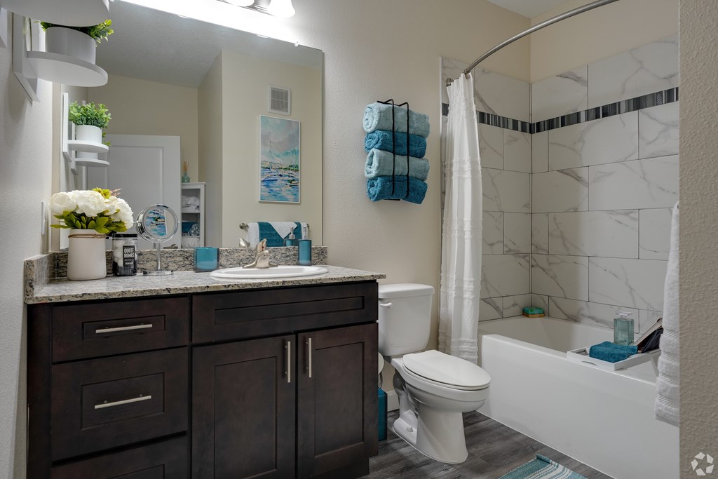 A bathroom with a white tub, toilet, and sink.
