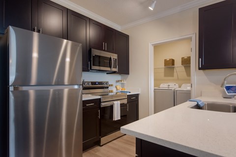 a kitchen with stainless steel appliances and white counter tops and black cabinets