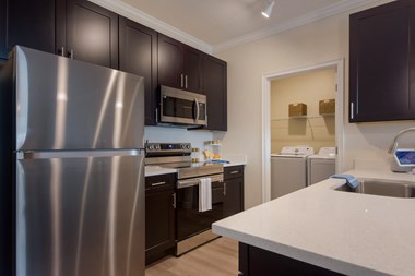 a kitchen with dark cabinets and white countertops