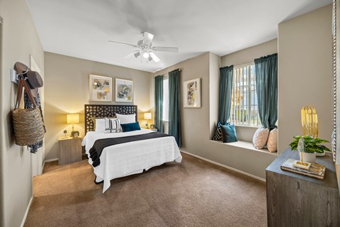 A bedroom with a large bed and a ceiling fan.