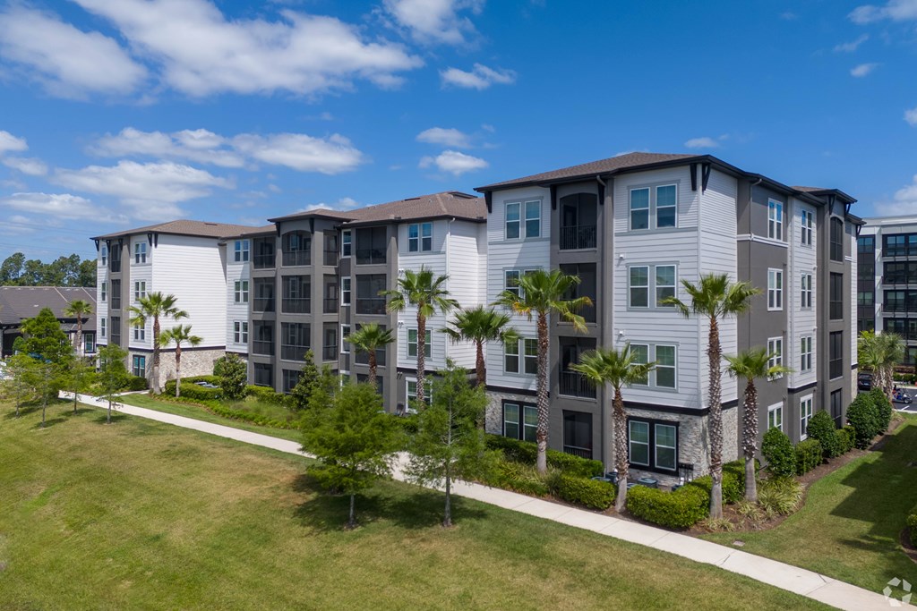 A large apartment complex with a green lawn in front.