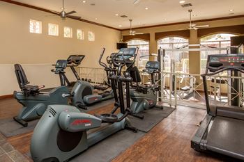 a gym with treadmills and other exercise equipment at The Fairways by Picerne Apartments, Las Vegas, NV