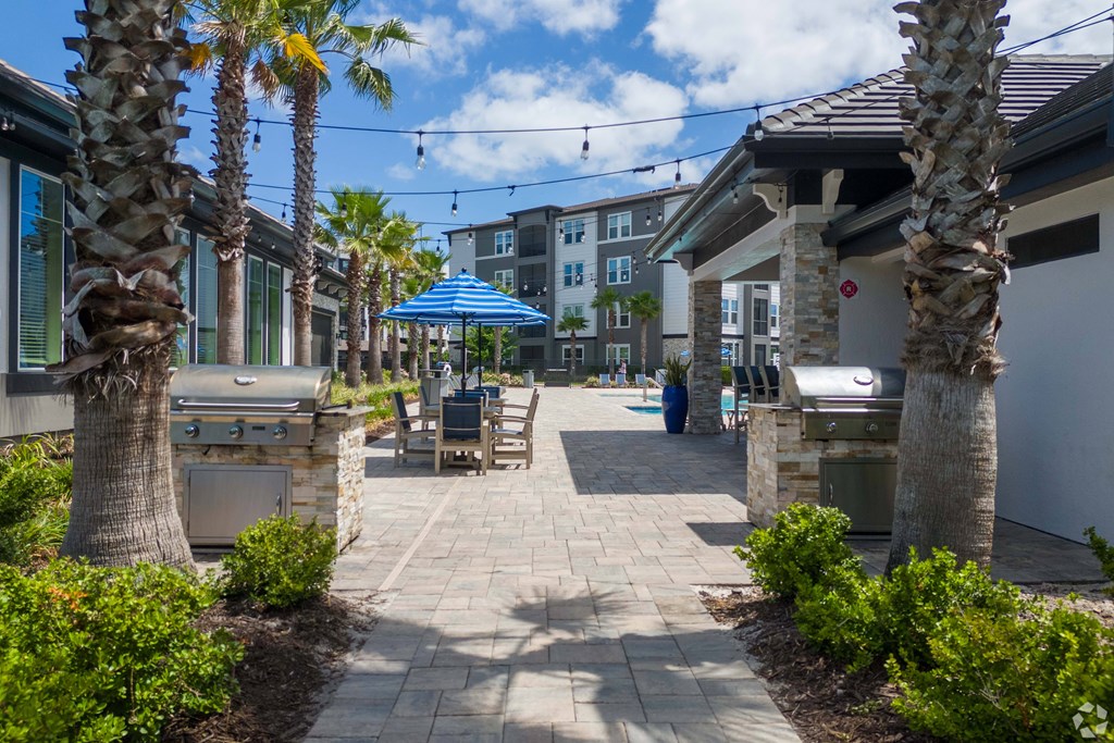 A sunny day at a resort with palm trees and a walkway.