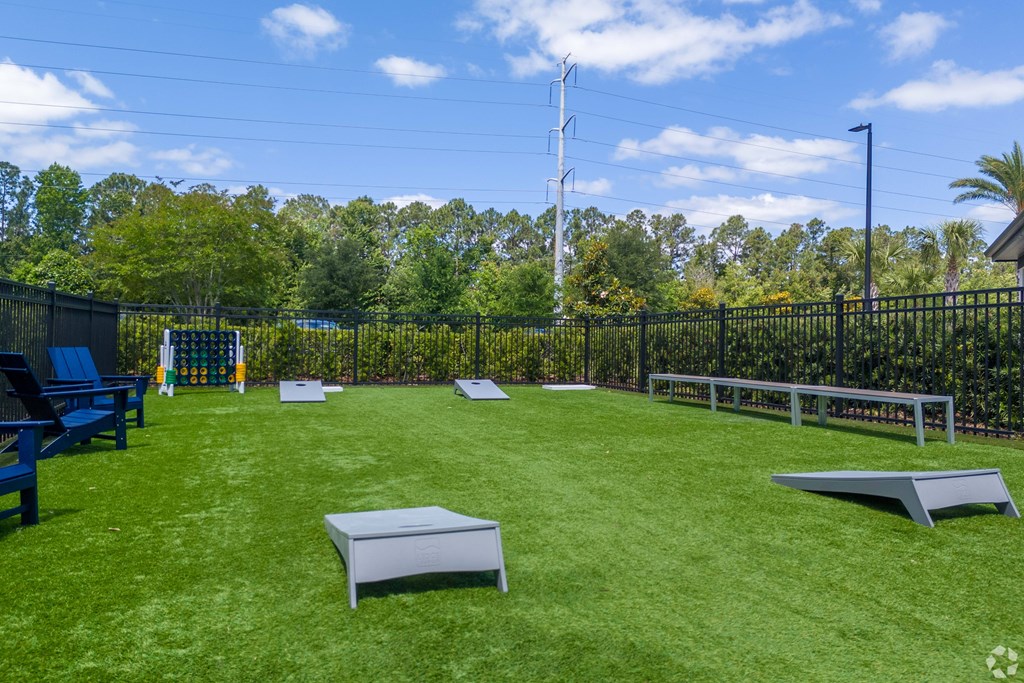 A backyard with a green lawn and a fence.