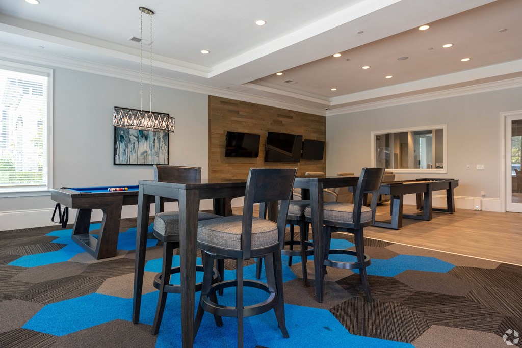 A modern dining room with a large table and chairs.