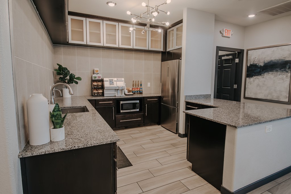 Clubhouse kitchen with appliances and a granite countertop.