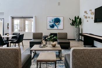 A living room with a brown sofa, a coffee table, and a painting on the wall.