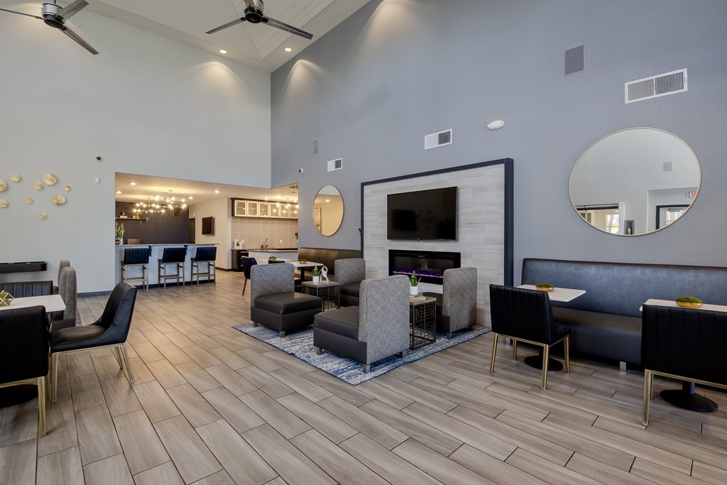 A modern clubhouse with a fireplace and bar area in the background.