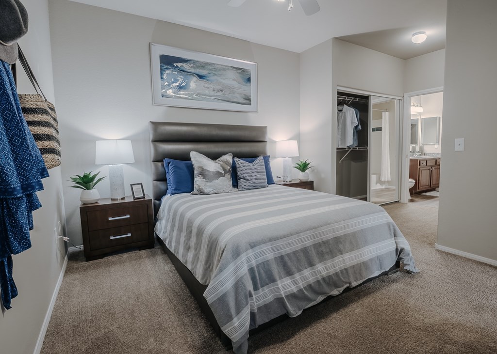 A bedroom with a large bed and a painting on the wall.