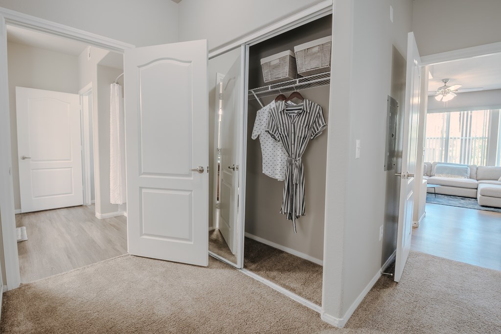 A white closet with a striped shirt hanging on it.