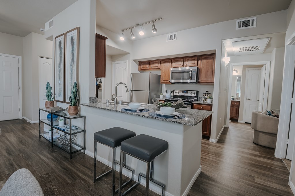 A kitchen with a bar stool and a counter.