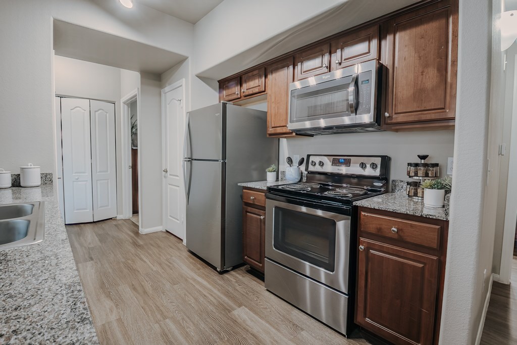 A modern kitchen with wooden cabinets and stainless steel appliances.