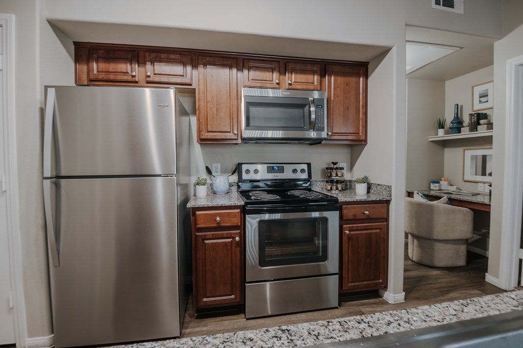 A modern kitchen with stainless steel appliances and wooden cabinets.