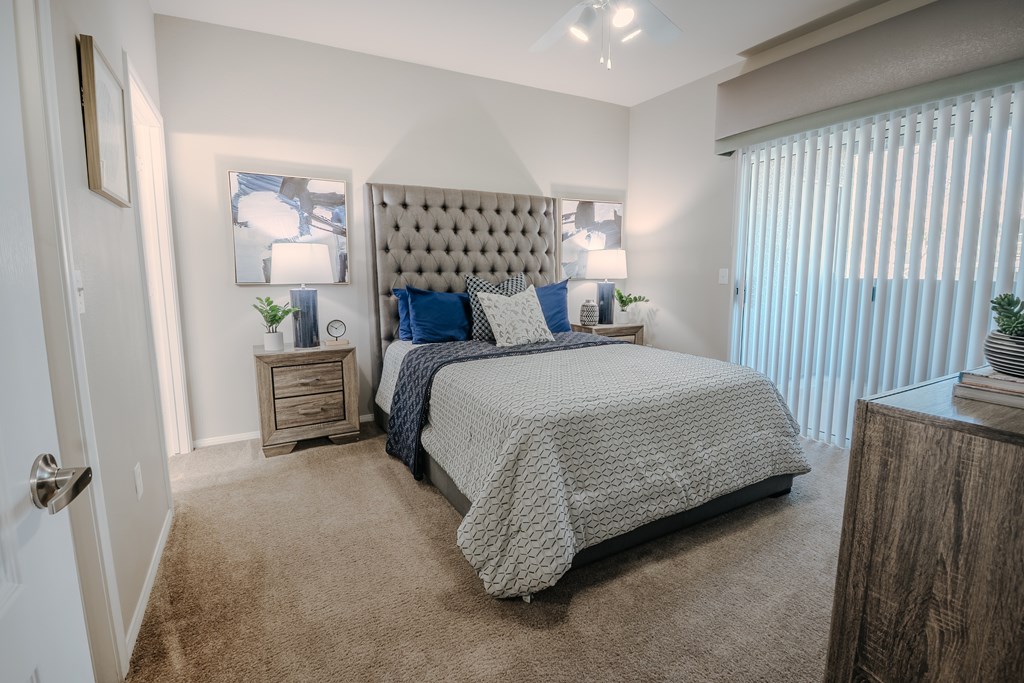 A bedroom with a large bed and a tufted headboard.