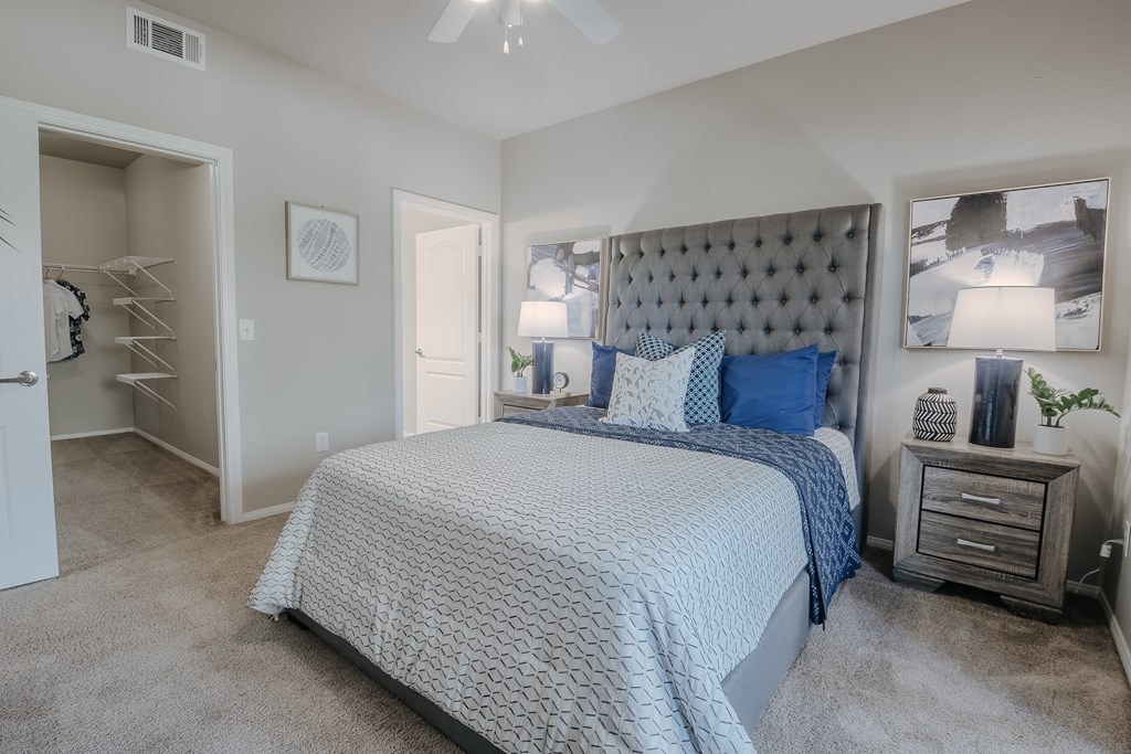 A bedroom with a bed, nightstand, and a ceiling fan.
