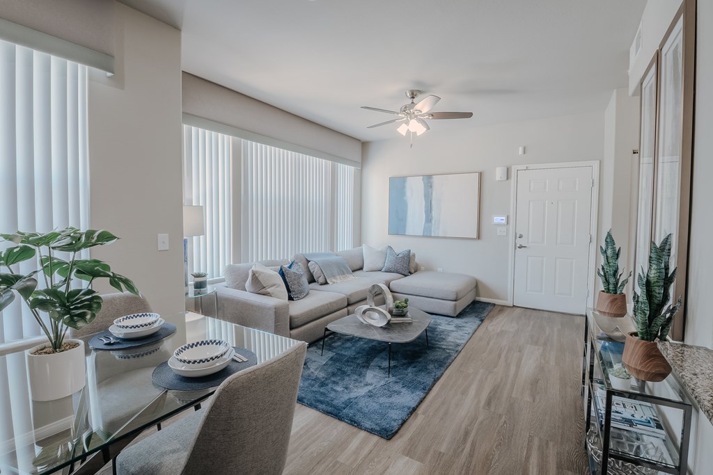 A living room with a couch, a coffee table, and a ceiling fan.