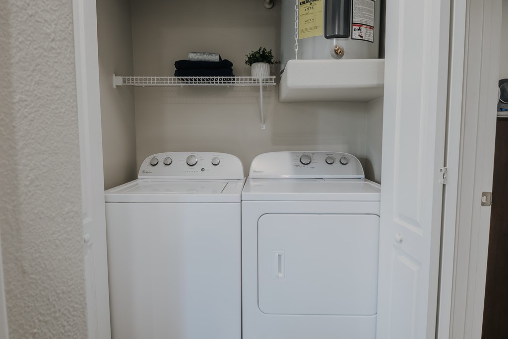 Full size washer and dryer in a small laundry room.