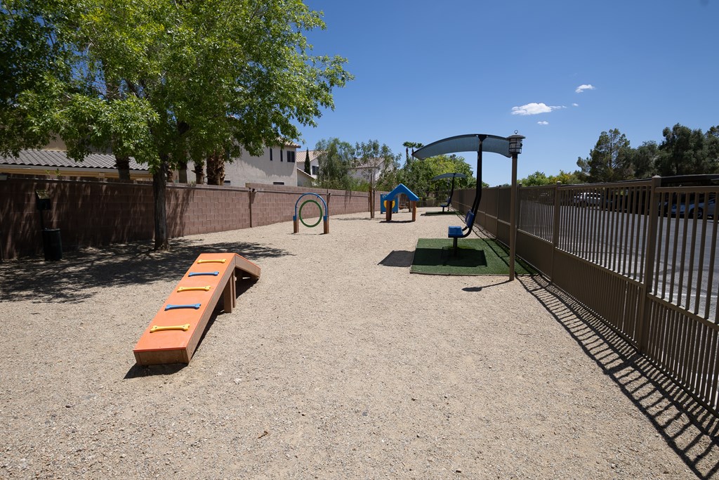 Large pet park with gravel run, agility equipment and covered seating.