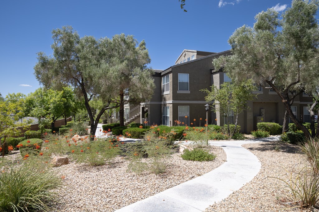 Walking path to a building surrounded by vegetation and trees.