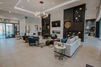 Spacious clubhouse with high ceiling, lots of cozy seating, and fireplace at Level 25 at The Curve by Picerne, Las Vegas, NV