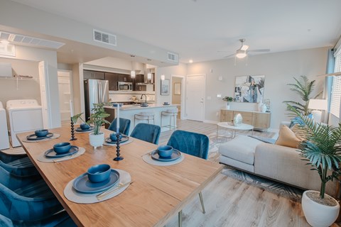 A modern dining room with a wooden table set for a meal.