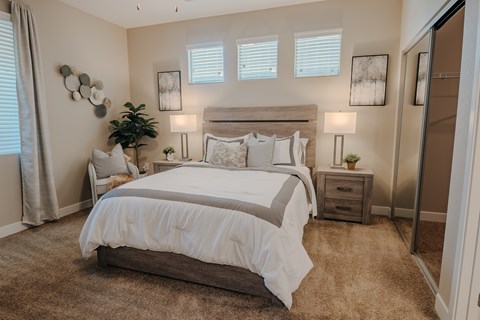 Primary bedroom with cozy bedroom furniture and windows.